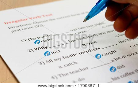multiple choice english exam with hand on table