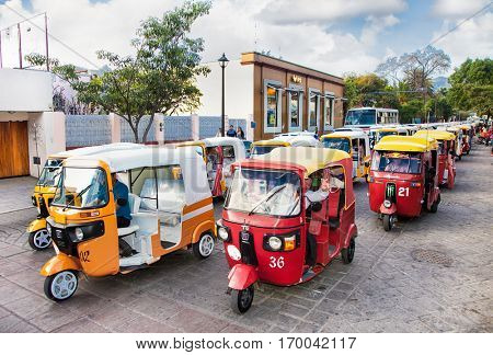 OAXACA, MEXICO- DEC 10, 2015:  Taxi tuk-tuk column at the street of Oaxaca on Dec 10, 2015, Mexico. 