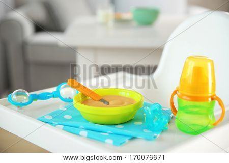 Highchair with healthy baby food at home. Child feeding concept
