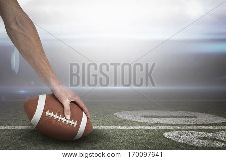 Close-up of American football player placing the ball against american football arena 3D