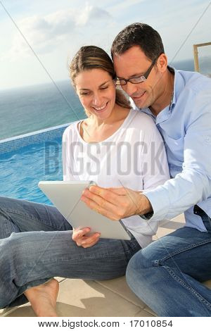 Счастливая пара, с помощью электронных таблетка, бассейн