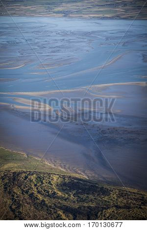 aerial view of the mudflat coastline at low tide with water winding in the mud and sand bank Frisian island Ameland The Netherlands