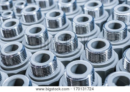 Polypropylene Plumbing connection fittings for plastic pipes. Orderly arranged in neat rows. Abstract industrial background.