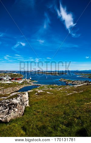 Norwegian summer scenery with sea green meadow and deep blue sky with some long shape clouds