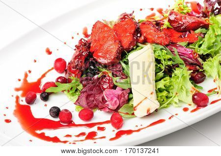 Salad with roasted duck fillet, berry sauce, cheese and fresh herbs