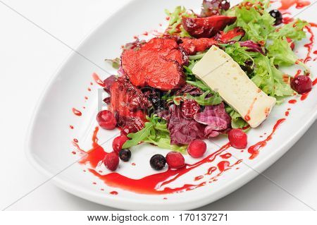 Salad with roasted duck fillet, berry sauce, cheese and fresh herbs