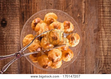 Group of sweet cream puffs on glass tray.