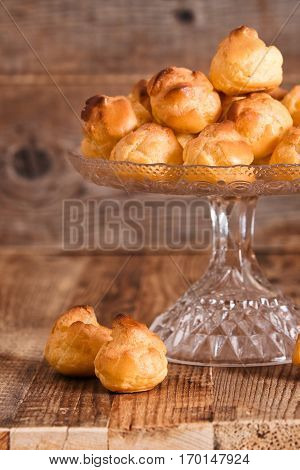 Group of sweet cream puffs on glass tray.