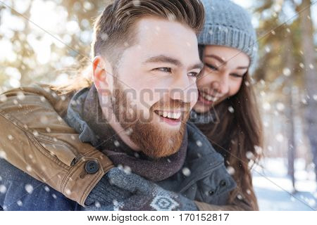 Smiling young couple having fun in winter park