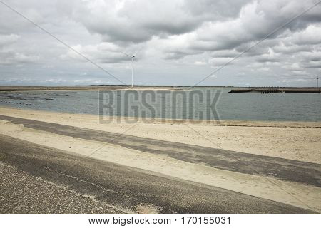 Seaside view with power windmills, a dike and dramatic sky, Haringvliet, The Netherlands