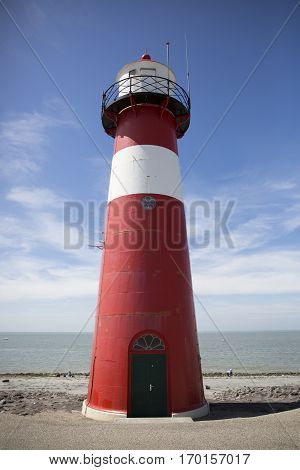 Red and white lighthouse on a blue sky background Westkapelle The Netherlands