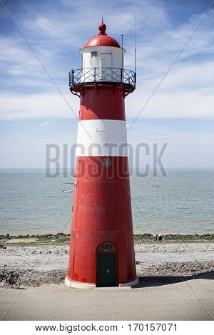 Red and white lighthouse on a blue sky background Westkapelle The Netherlands