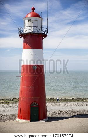 Red and white lighthouse on a blue sky background Westkapelle The Netherlands