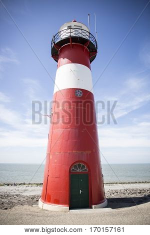 Red and white lighthouse on a blue sky background Westkapelle The Netherlands