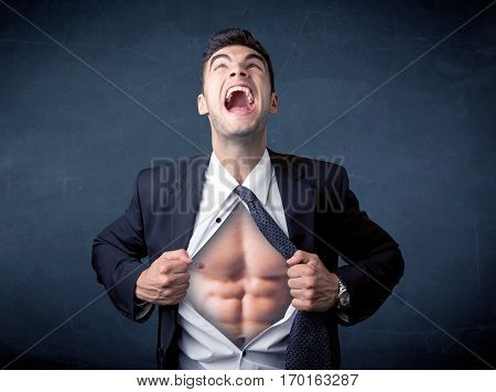 Businessman tearing off his shirt and showing mucular body concept on background