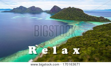 Relax motivational inspiring quote with tropical paradise island with bright smooth mirror sand & crystal clear water with rocky shore in the island of Semporna, Borneo