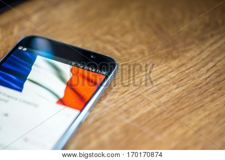 Smartphone On Wooden Background With 5G Network Sign 25 Per Cent Charge And France Flag On The Scree