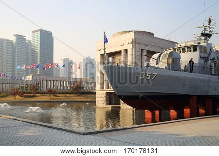 SEOUL - NOV 4, 2015: Military ship with cannonry in reservoir and highrise apartment buildings in military museum. In military museum was ceremony to mark 60th anniversary of armistice in Korea