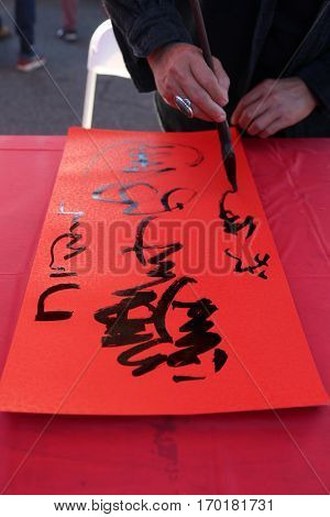 MONTERY PARK, CALIFORNIA JANUARY 28, 2017: - A person writes a fortune in Chinese calligraphy reading Year of the Chicken at a Lunar New Year Celebration. 