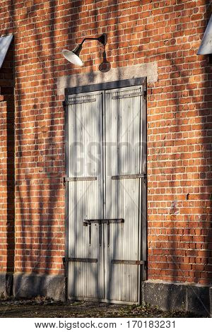 red brick wall and wooden door with vintage lamp
