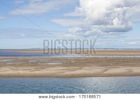 maritime seaside landscape with water sand bank and white cloud garonne estuary near Royan France
