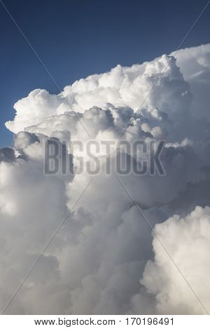 Close up on white fluffy storm clouds in front of blue sky