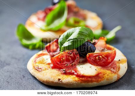 Mini pizza topped with cherry tomatoes and basil
