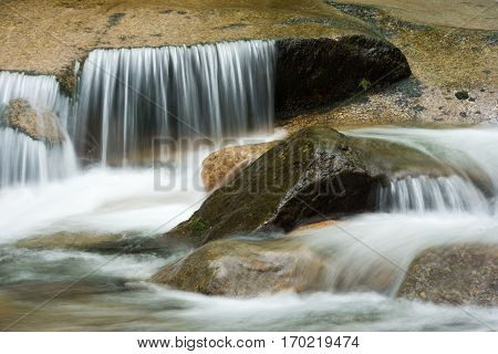 Flowing water over granite rocks at the Flume Gorge in Franconia New Hampshire