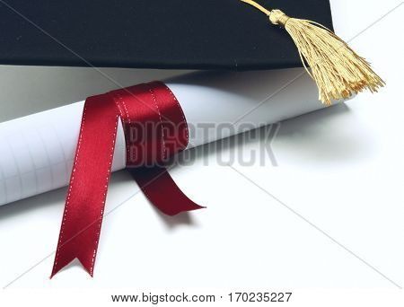 A university diploma with a red ribbon isolated on white