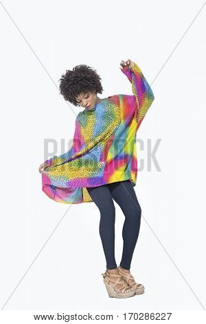 Full length of an African American woman in dashiki over gray background