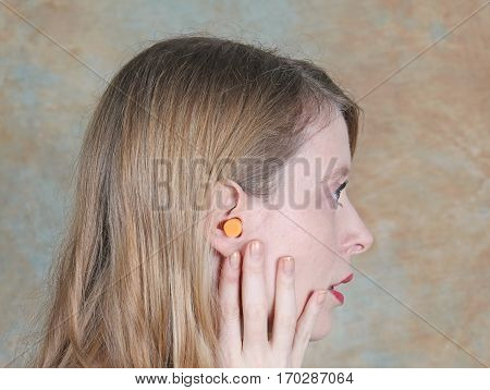 Young girl wearing ear plug inside her ear lobe