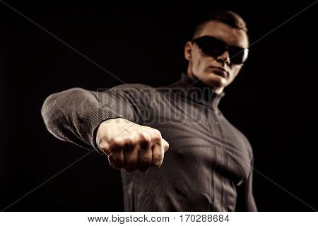 Right-hander punch. Close-up of a man's fist. Sunglasses. Studio shot.