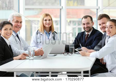 Team of doctors sitting at table in clinic
