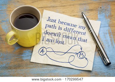 Just because my path is different, doesn't mean that I am lost - handwriting and doodle on a napkin with a cup of espresso coffee
