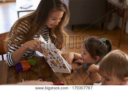 Mother Playing With Children On Table At Home
