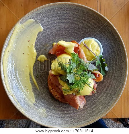 Eggs benedictine with crispy bacon on toasted Turkish bread
