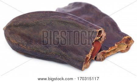 Closeup of Edible carob fruits over white background