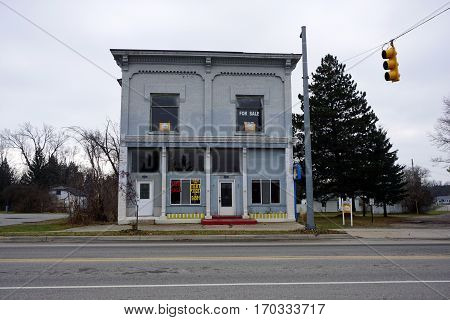 MANCELONA, MICHIGAN / UNITED STATES - NOVEMBER 27, 2016: A vacant historic brick building stands for sale near downtown Mancelona.