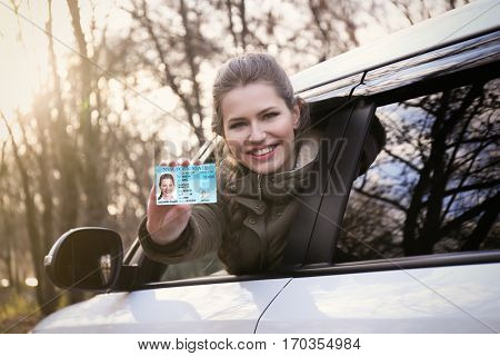 Woman with driving license in car