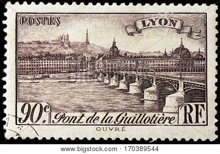 LUGA RUSSIA - FEBRUARY 7 2017: A stamp printed by FRANCE shows view of the Bridge Guillotiere in Lyon - city in east-central France in the Auvergne-Rhone-Alpes region circa 1939