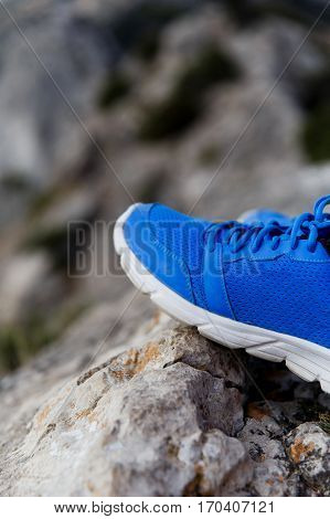 Blue sneakers on background of mountains in afternoon