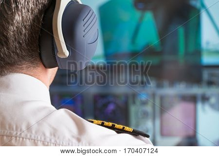 Close up of captain's epaulettes and headphones in the cockipt of commercial airplane