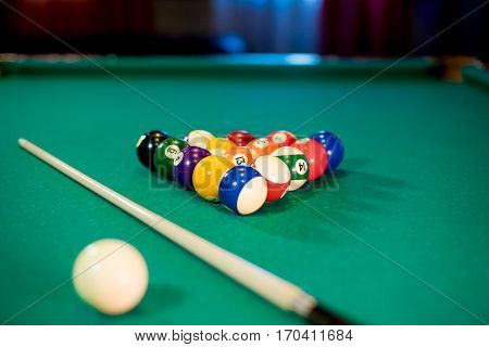 billiard table with billiard balls, cue and billiard triangle