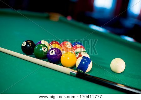 billiard table with billiard balls, cue and billiard triangle