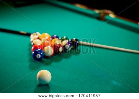 billiard table with billiard balls, cue and billiard triangle