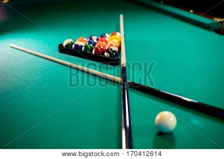 billiard table with billiard balls, cue and billiard triangle