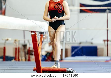 prepare young female athlete gymnast on balance beam