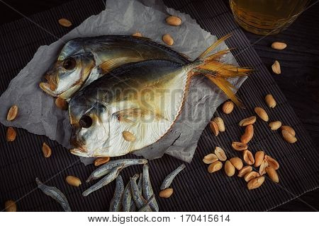 Beer and dried fish on dark wooden table. Beer and beer snack.