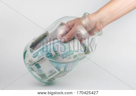 Hand Takes Out A Three-liter Glass Jars Thousand Russian Rubles