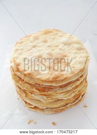 Cooking process. Preparing multi-layered cake. Crusts for homemade mille feuille. Big pile of fresh pancakes. Top view.